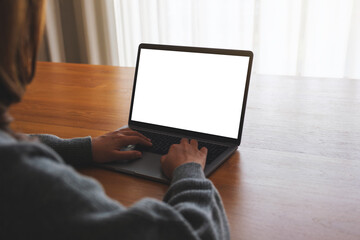 Mockup image of a woman using and working on laptop computer with blank white desktop screen