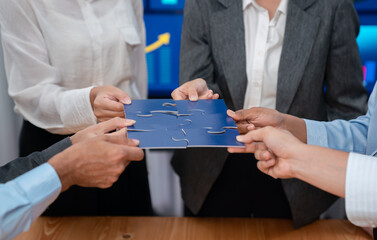 Corporate officer worker collaborate in office, connecting puzzle pieces with report paper on table...