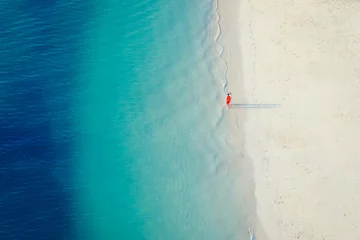 Foto op Canvas High angle of view of two tourist on wonderful white sandy beach and turquoise ocean, minimalist photo and copy space, Zanzibar in Tanzania. © robertobinetti70
