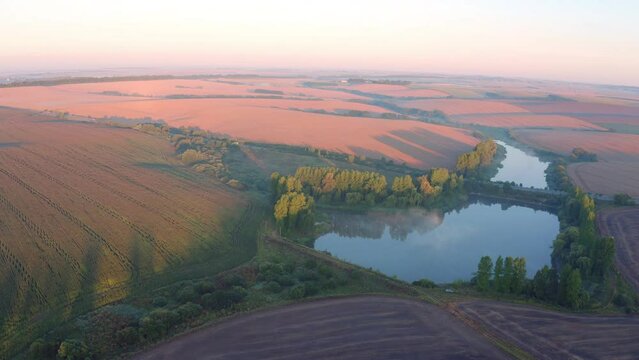 4k drone forward video (Ultra High Definition) of Ternopil outskirts with two lakes and asphalt road on the midle. Spectacular morning view of hte Ukrainian countryside with field of wheat.