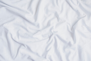 Crumpled white sheet seen from above. White fabric texture and background - obrazy, fototapety, plakaty