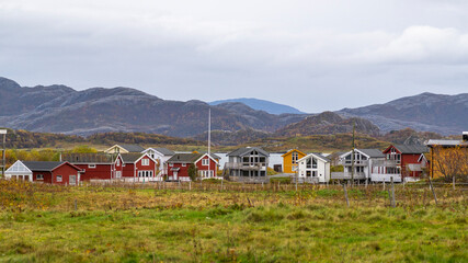 red house by the ocean on white sandy beach, colorful houses on the shore of the North Atlantic. wooden holiday home on the islands of Hillesøy and Sommarøy. Holidays in Troms, Northern Norway.