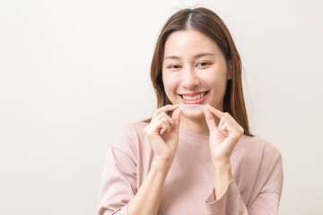 Dental invisible braces, beautiful smiling asian young woman holding invisalign braces, wearing...