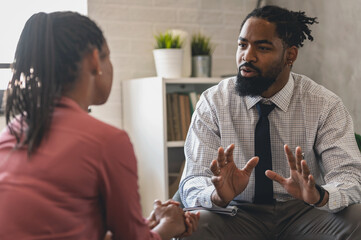 A psychotherapist session with a patient. African-American women and men have a meeting. 