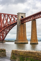 Old red brick and metal bridge across the Firth of Forth in Edinburgh, Scotland.