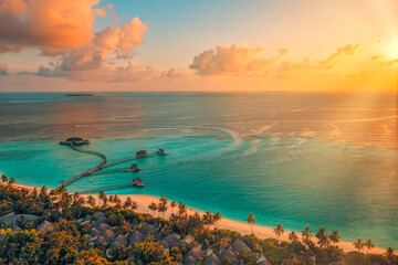 Aerial sunset of beautiful Maldives paradise tropical beach. Amazing colorful sea sky bay water,...