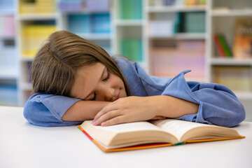 Schoolgirl napping at the desk at school after the lesson