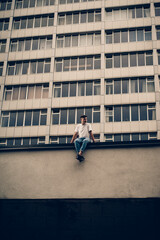 guy sitting against the background of a tall building