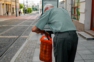 Old man with a bag. Hunchbacked grandfather, old age and wisdom.