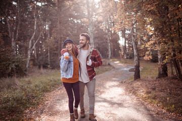 Obraz premium Young happy caucasian couple hiking on a park trail