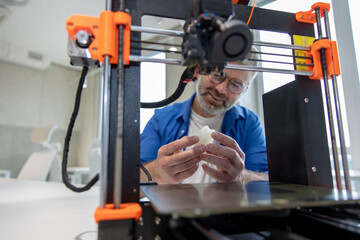 Man designer printing design using 3D printer in office.
