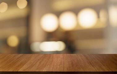 Mock up for space. Empty dark wooden table in front of abstract blurred bokeh background of...