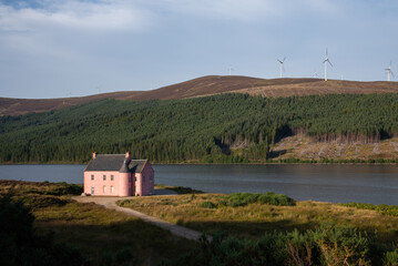 Abandoned Pink house lying by Loch Glass. True scottish landscape with heath and midges. 
