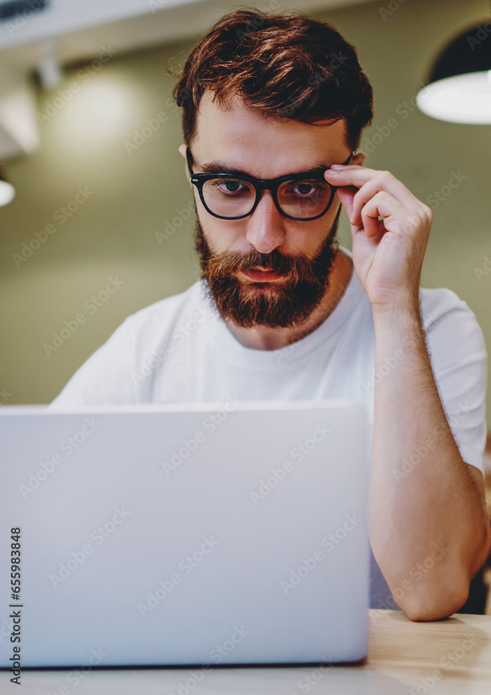 Poster smart male student watching tutorial learning information via courses on netbook