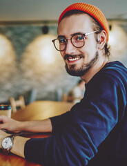 positive cheerful hipster blogger sitting on publicity area with modern laptop computer