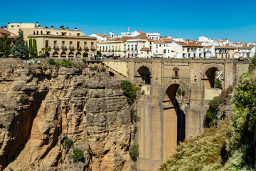 view of The Puente Nuevo bridge over a rocky canyon dividing the city of Ronda in Andalusia...