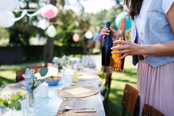 Young beautiful woman preparing refreshments for a summer garden party.
