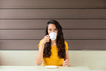 Latin woman drinking coffee in cafe