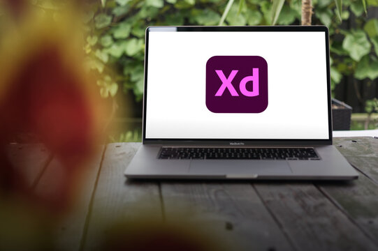 Adobe XD logo, a vector design tool for web and mobile applications, developed and published by Adobe Inc., displayed on a MacBook Pro screen