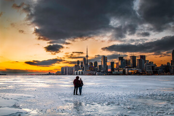 Watching sunset behind Toronto skyline over frozen Lake Ontario (Toronto, Canada)
