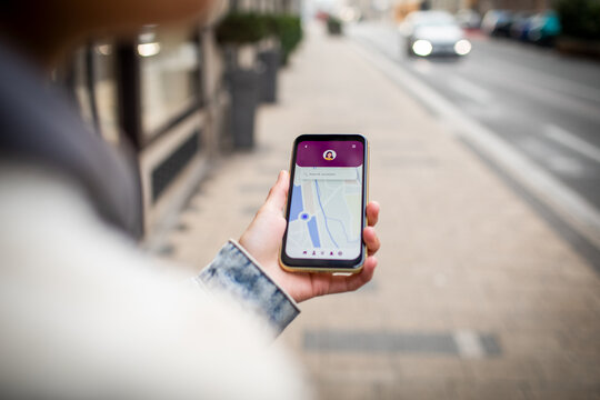 Close up of a young woman using her smartphone to navigate through the city