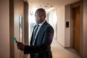 Young African American businessman entering his room at a hotel during a business trip