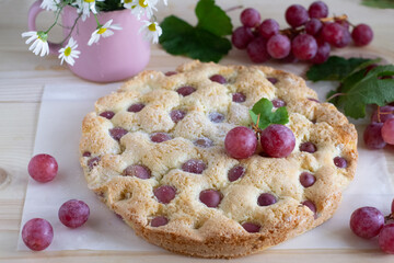 Red grape pie on wooden table  
