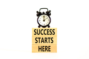 Success starts here symbol. Concept word Success starts here on beautiful wooden block. Black alarm clock. Beautiful white background. Business motivational success starts here concept. Copy space.