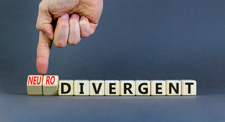 Divergent or neurodivergent symbol. Concept words Divergent Neurodivergent on wooden blocks. Beautiful grey table grey background. Psychologist hand. Divergent or neurodivergent concept. Copy space.