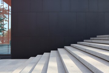 The black wall of the building and light stairs