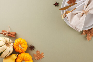 Preparing a Thanksgiving table for a memorable celebration. Top view shot of plates, cutlery, napkin, pumpkins, classic fall elements on pastel green background with advert zone