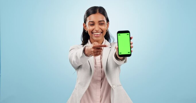 Happy woman, business and pointing to green screen of phone for advertising space, sign up offer and mockup newsletter in studio. Portrait of indian worker show mobile announcement on blue background