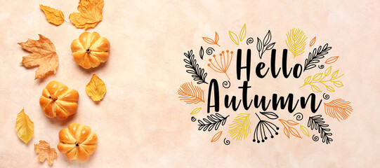 Banner with text HELLO AUTUMN, leaves and pumpkin shaped buns on beige background