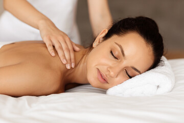 Fototapeta na wymiar Young Woman Getting Shoulders Massage In Luxury Beauty Salon