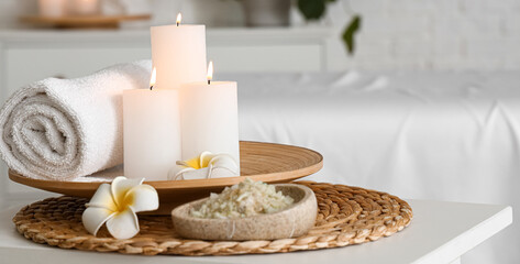 Obraz na płótnie Canvas Burning candles, sea salt, towel and flowers in spa salon