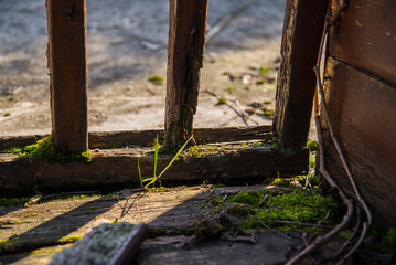 Outdoor corner with wooden floor and weathered fence, outside in dim sunshine
