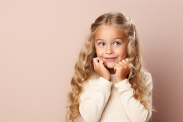 A little girl posing for a picture with her hands on her chin. This image can be used for various purposes, such as advertisements, blog posts, or social media content.