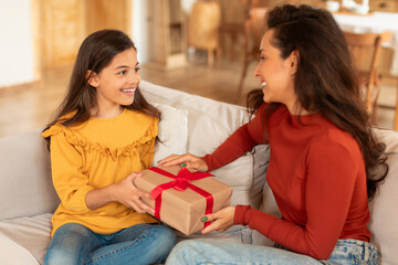 Smiling Kid Girl Giving Birthday Gift To Mom At Home