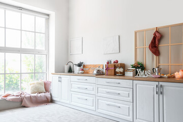 White kitchen counter with burning candles and Christmas decor