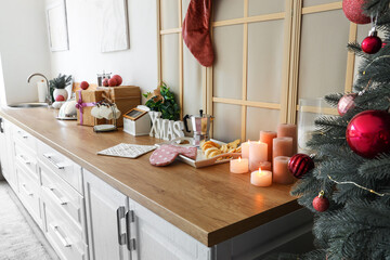 White kitchen counter with burning candles and Christmas decor