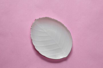 white leaf-shaped plate on a pink background. empty white plate. template white plate. top view