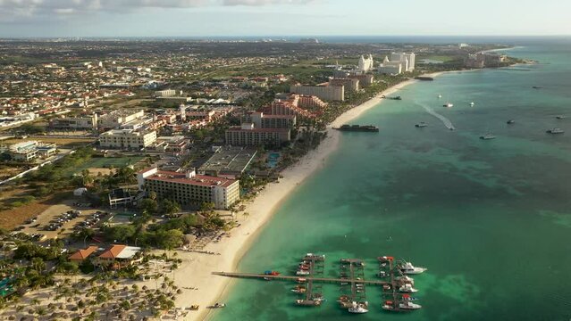 Vista a&eacute;rea de Palm Beach, Aruba, con playa, hoteles y muelle captada por drone en 4K.