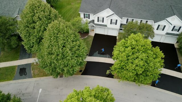 Drone wide shot of Driveway sealcoating pavement, Near private houses in the suburbs. Top view shot