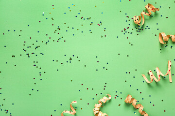 Christmas composition with ribbons and confetti on green background