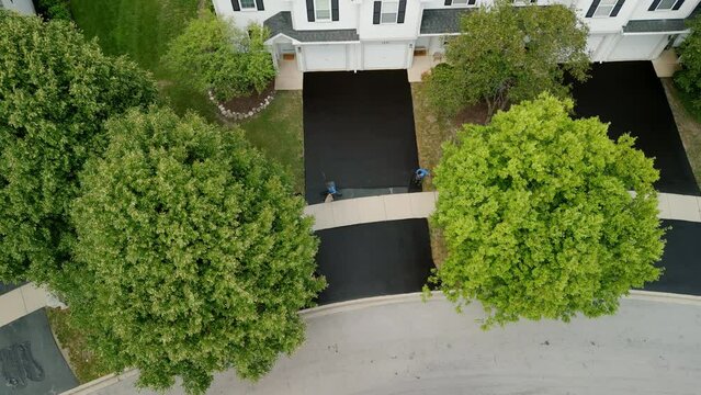 Aerial shot of Driveway sealcoating pavement, Near private houses in the suburbs. Top view aerial shot