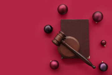Judge's gavel with law book and Christmas balls on red background