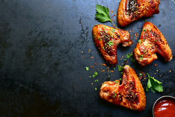 Grilled spicy chicken wings in mexican or chinese stile with ketchup . Top view with copy space.