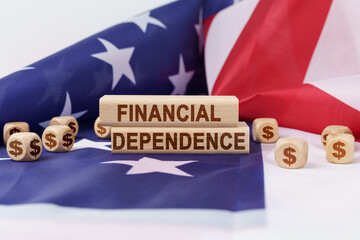 On the US flag and wooden plates with the inscription - financial dependence