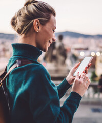 millennial woman chatting via blank phone during Spanish vacations