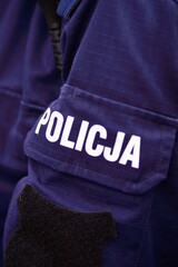 Police sign - logo on the back of the police uniform. Policja. © Grand Warszawski